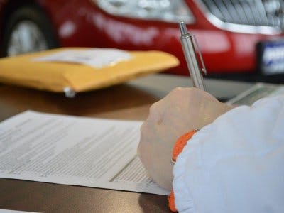 Man signing a vehicle equity release loan