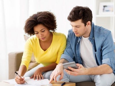 Couple budgetting to save money on expenses